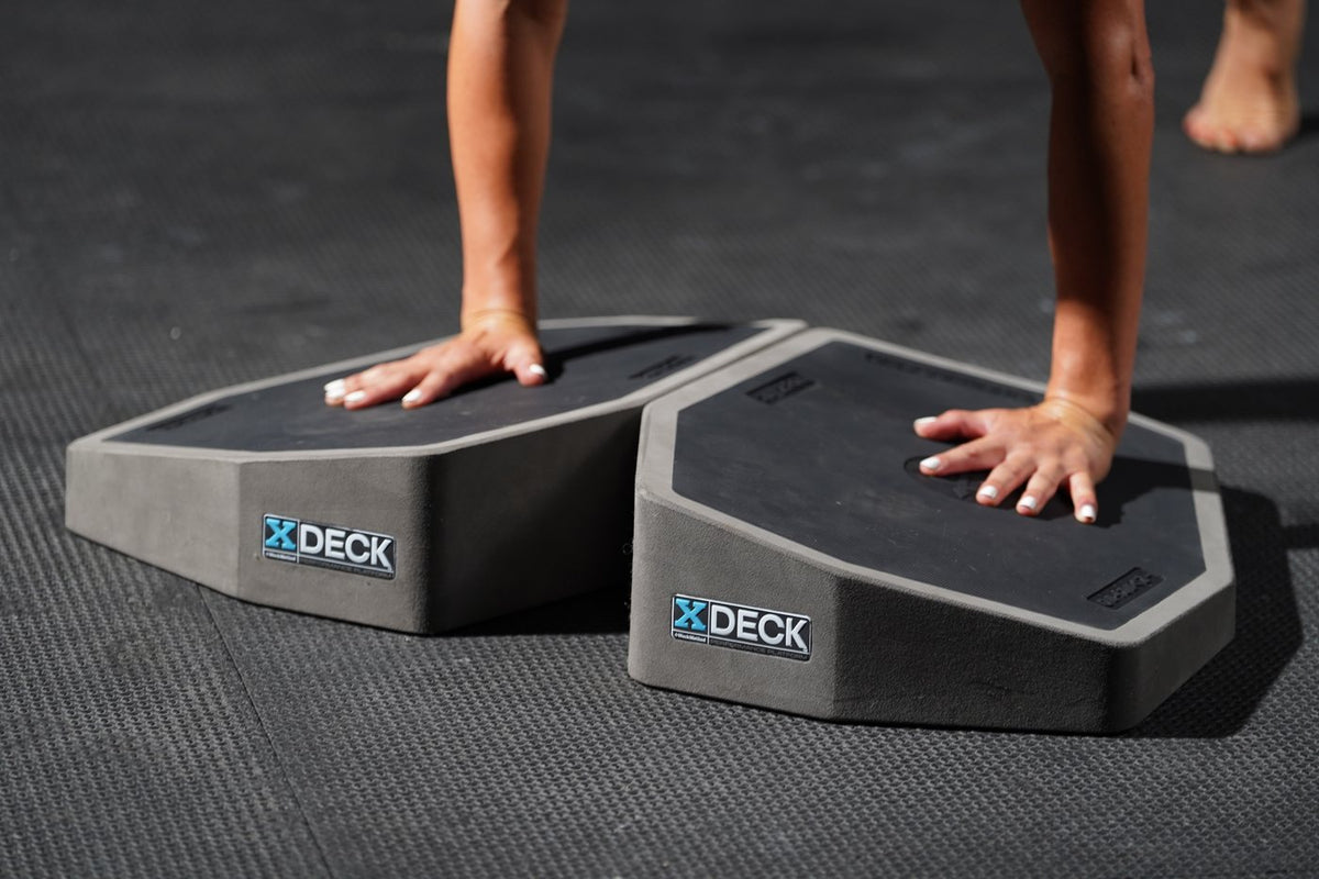 Hands planking across both XDECK platforms